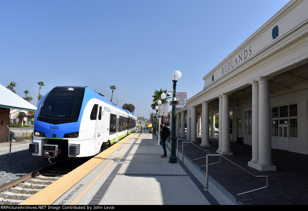 An early afternoon westbound coming into Redlands-Downtown Station with the former Santa Fe RR Redlands Depot building on the right 